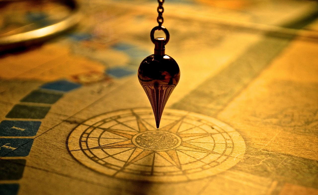 Pendule divinatoire au-dessus d'un cadran de radiesthésie